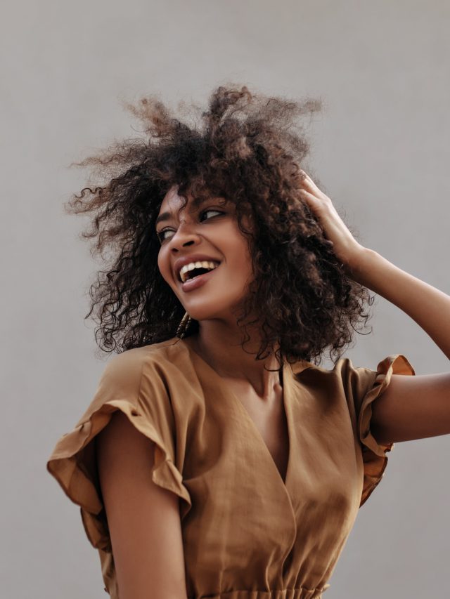 Excited,Lady,In,Brown,Blouse,Touches,Hair,And,Looks,Back.