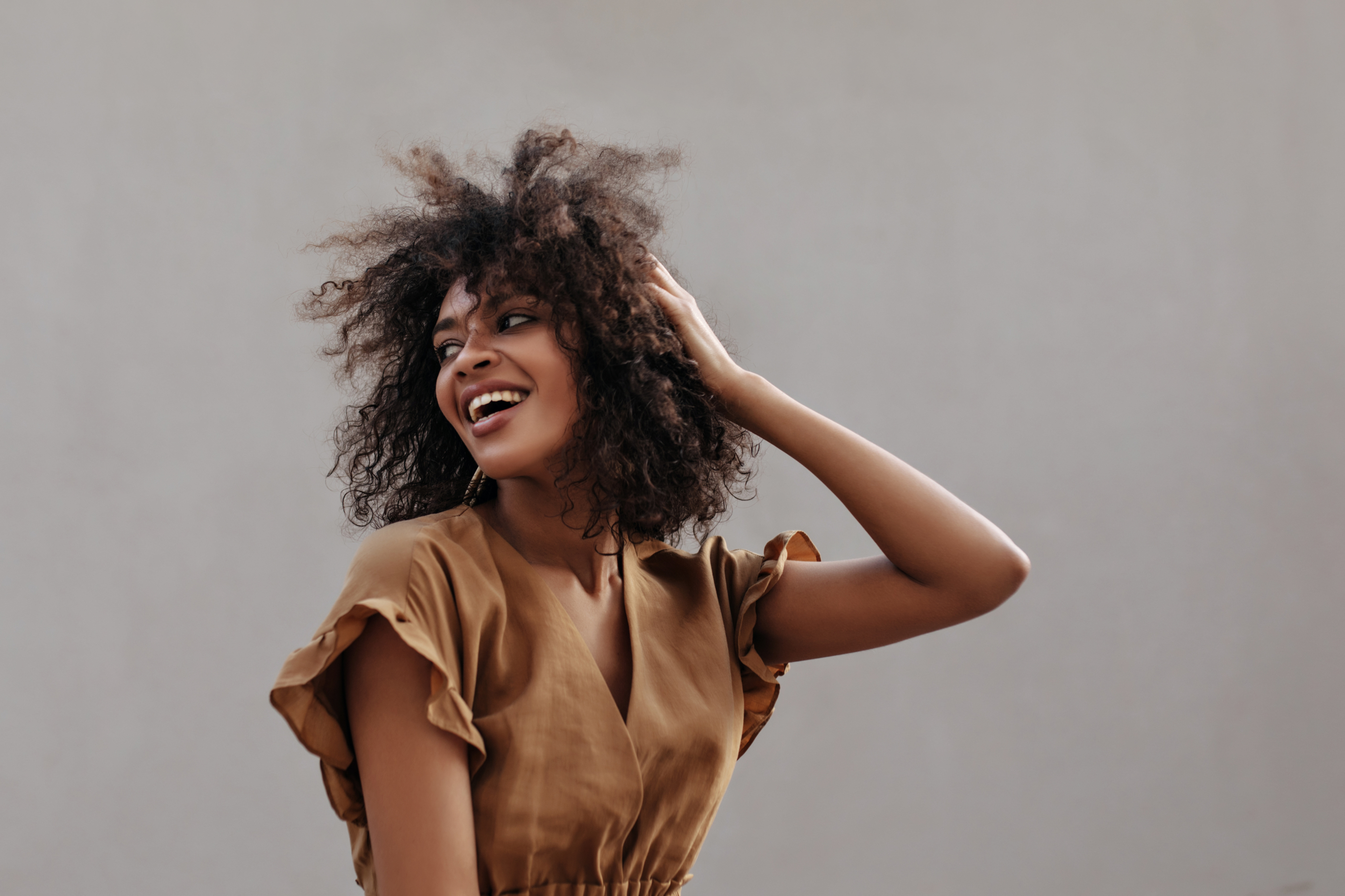 Excited,Lady,In,Brown,Blouse,Touches,Hair,And,Looks,Back.